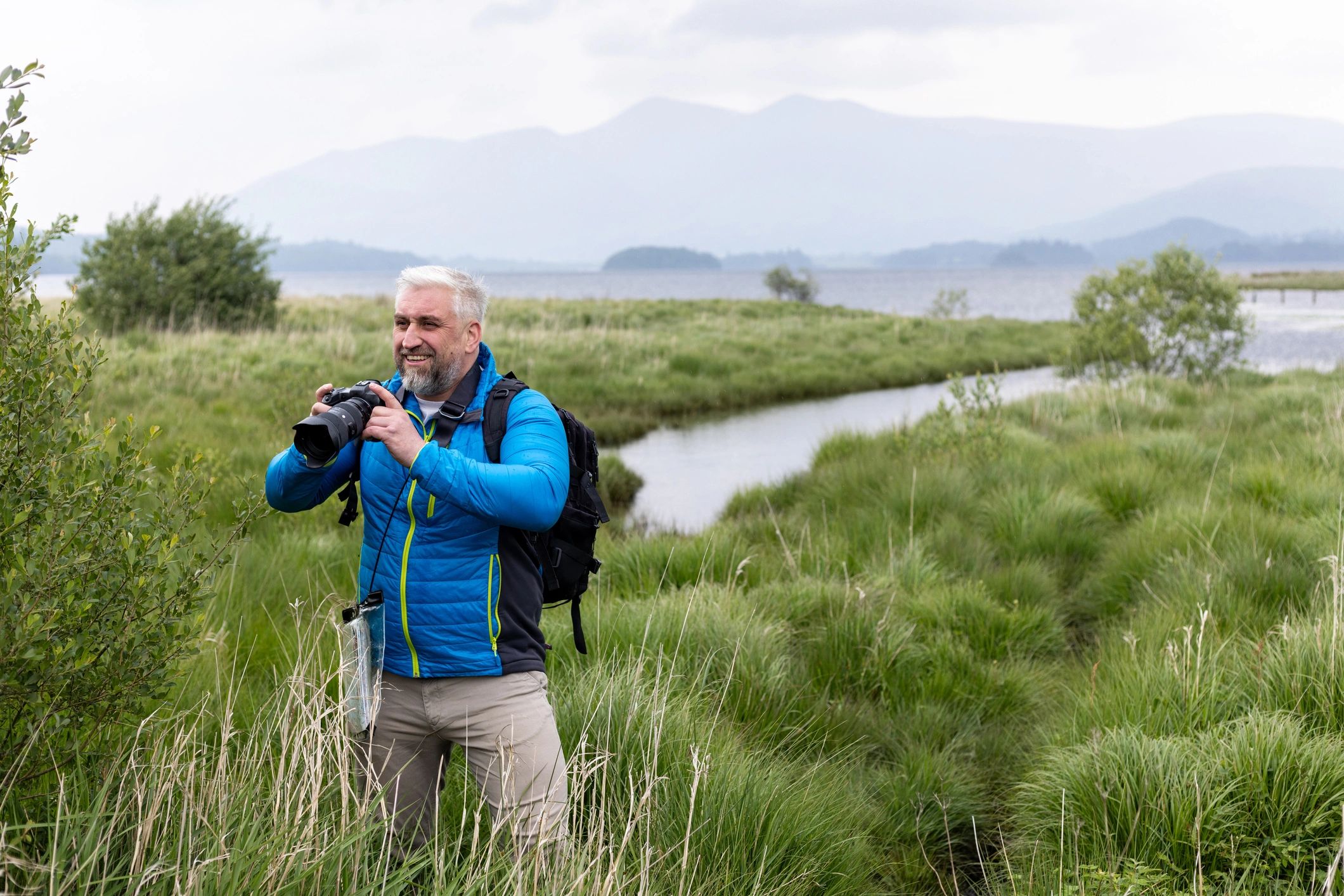 Photographer exploring a marsh landscape with camera