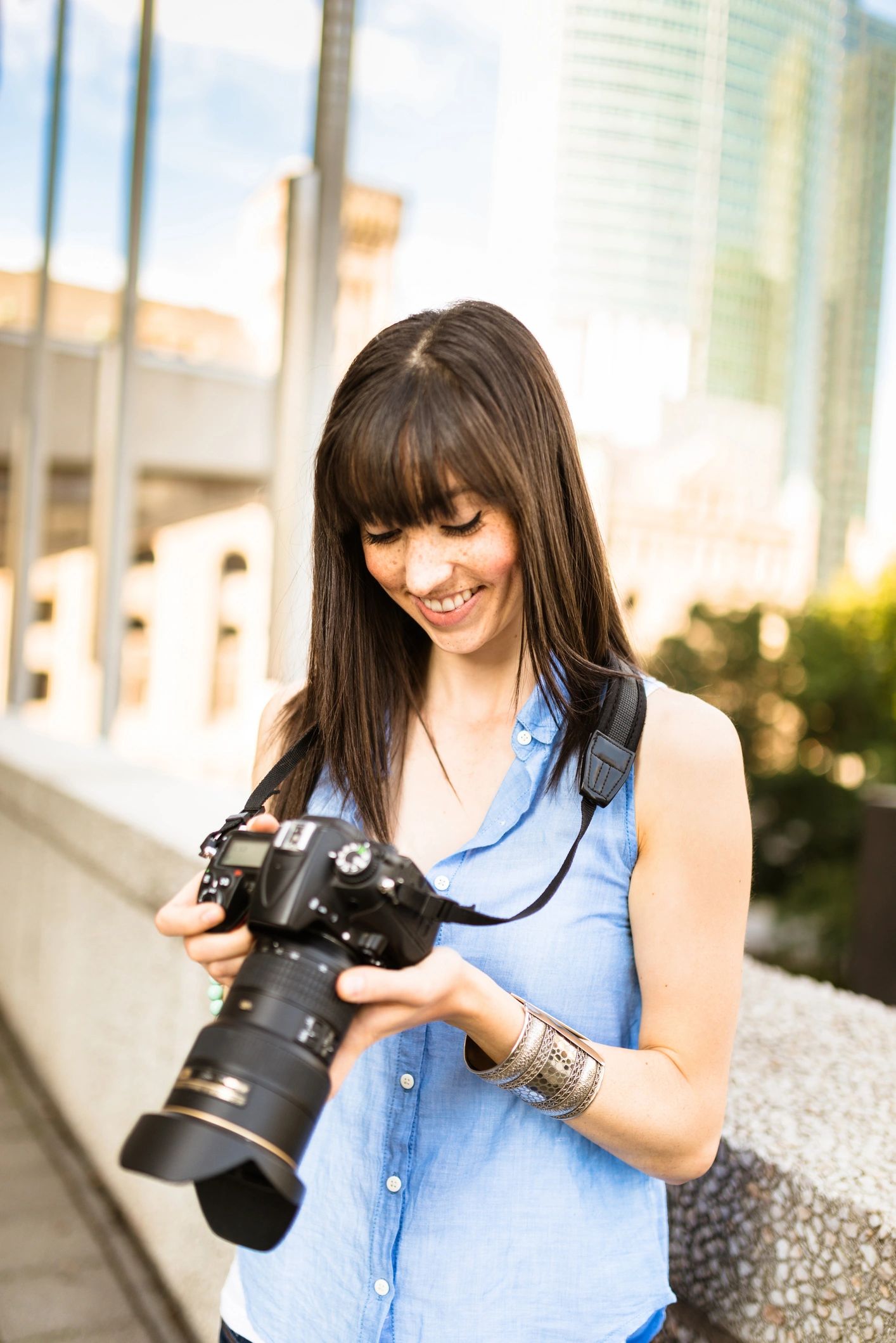 Woman holding camera outdoors